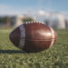 American football ball on grass blury background